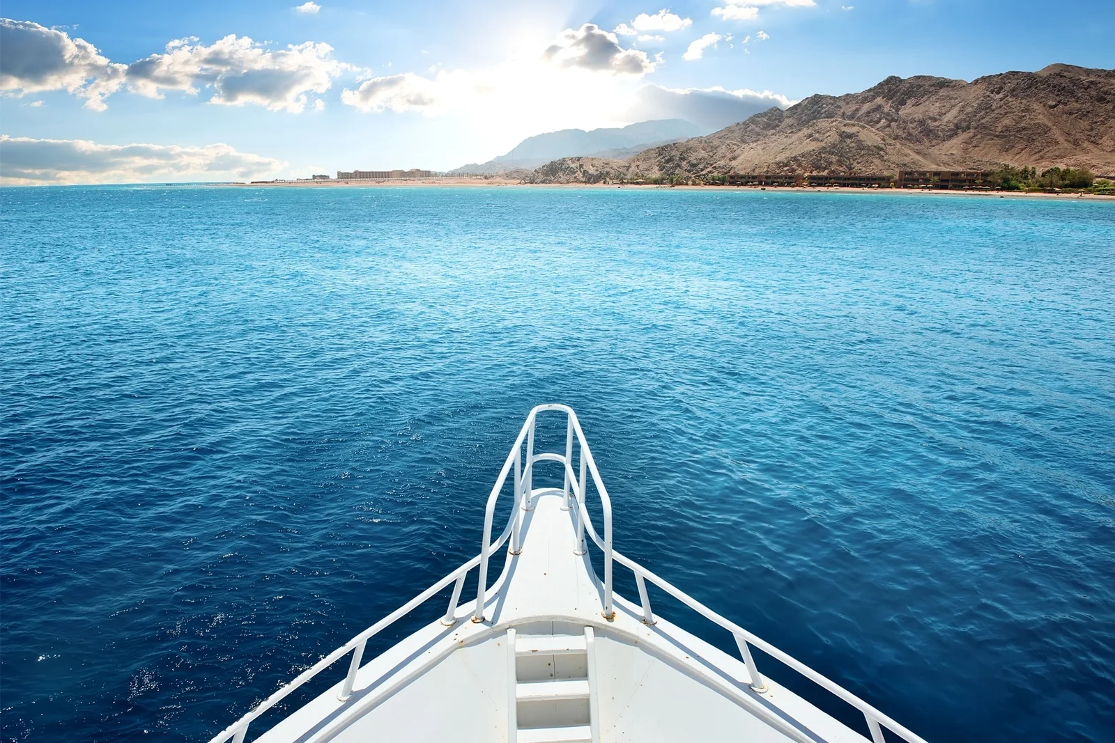 A boat facing the mountains and open waters of the Red Sea
